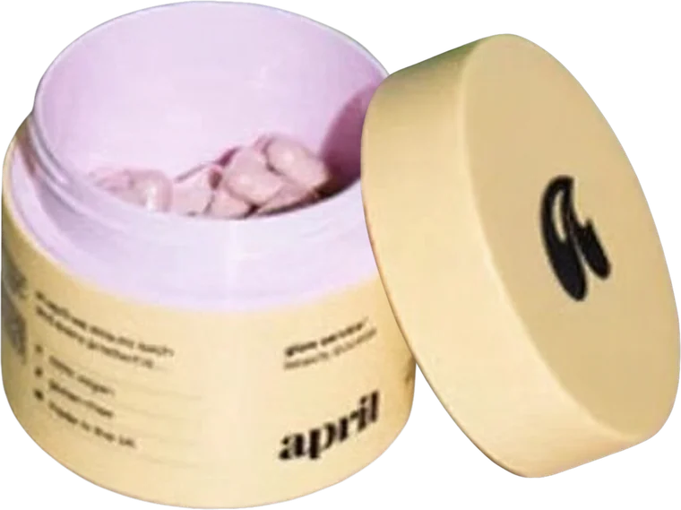 An open pastel supplement jar of capsules with its lid propped beside it